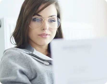 Junge Frau mit Brille begutachtet ihr Motivationsschreiben und Lebenslauf