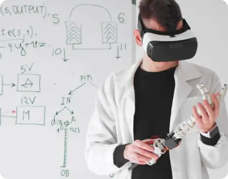 Physik Vertiefung –wissenschaftlicher Mitarbeiter blickt durch die VR-Brille. In seiner Hand hat er eine Roboterarmprothese