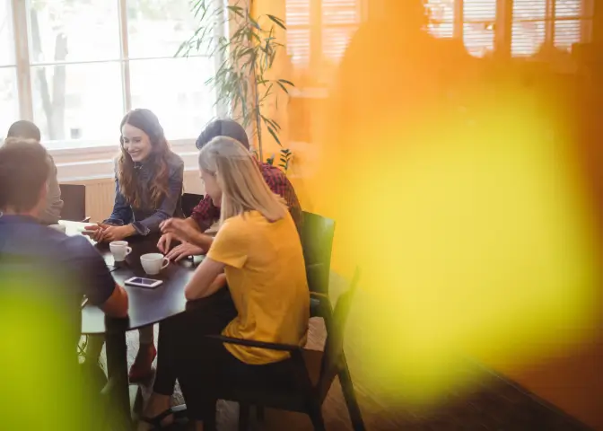 Junges Team sitzt gemeinsam am Tisch