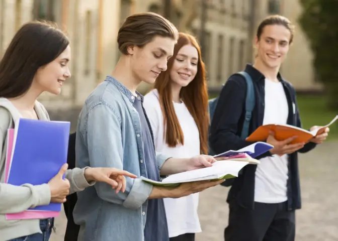 Infos über Unis und Partner. Gruppe junger Student|innen auf dem Uni Campus.