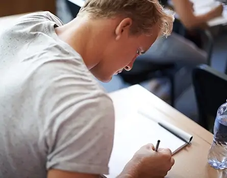 Junger Mann nimmt an Auswahltest an privaten Unis teil