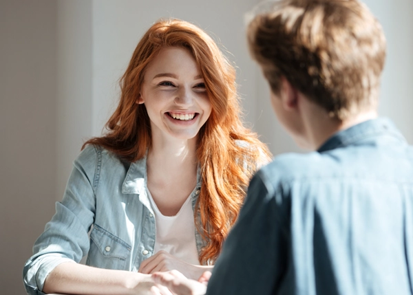 Junge freundliche Frau sitzt mit einem Berater in der Studienberatung Sprechstunde