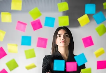 Blog planZ – Junge nachdenkliche Frau schaut auf viele Notizzetteln