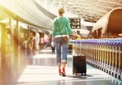 Blog PlanZ, junge Frau mit Koffer am Flughafen