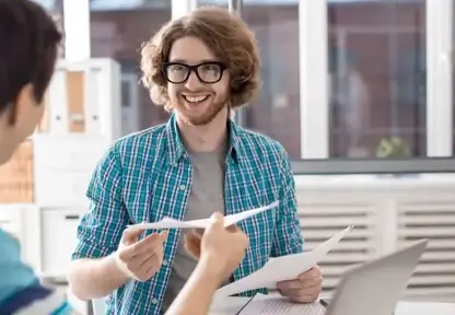 Junger Mann übergibt Bewerbungsunterlagen